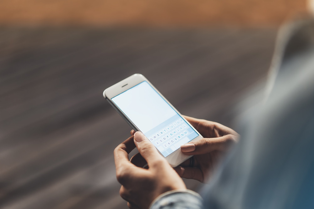 Girl,Pointing,Finger,On,Screen,Smartphone,On,Background,Wooden,Floor